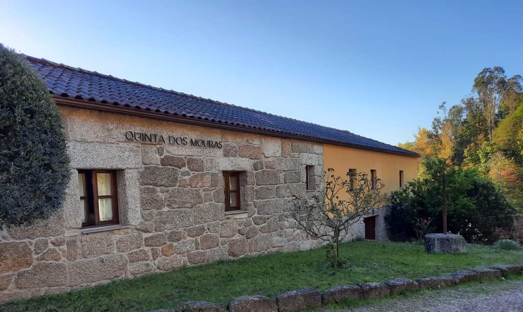 Fachada de granito da casa com a placa Quinta dos Mouras