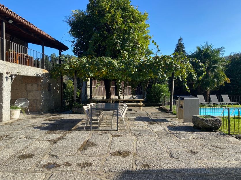Terraço com mesa e pérgola, junto à piscina